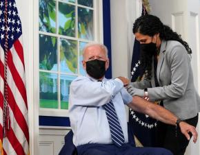 President Joe Biden holds up his sleeve to receive his coronavirus booster vaccination in the Eisenhower Executive Office Building's South Court Auditorium at the White House in Washington, September 27, 2021. REUTERS/Kevin Lamarque