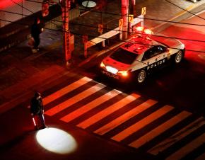 A police officer tries to control traffic on the street during an electric stoppage after an earthquake in Tokyo, Japan March 17, 2022. REUTERS/Issei Kato