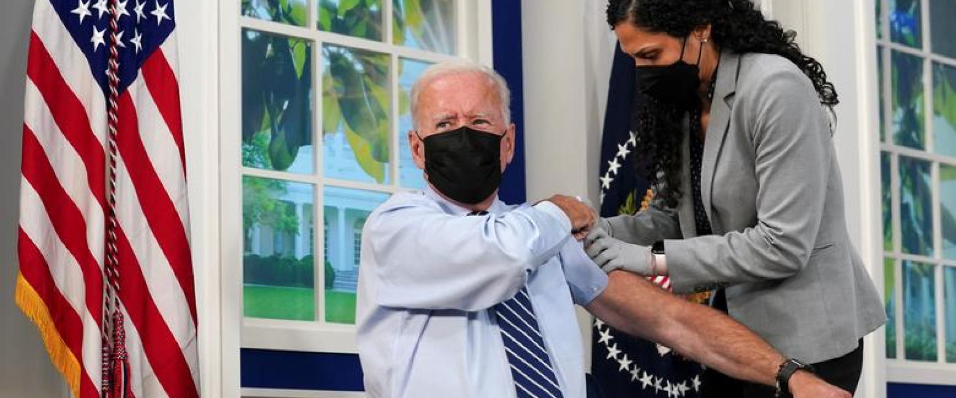 President Joe Biden holds up his sleeve to receive his coronavirus booster vaccination in the Eisenhower Executive Office Building's South Court Auditorium at the White House in Washington, September 27, 2021. REUTERS/Kevin Lamarque