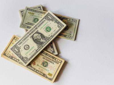 بعض العملات الأمريكية في صورة ، بعدسة  Alexander Schimmeck من موقع Unsplash